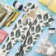 Load image into Gallery viewer, Taken from above on a light blueish green background, a very cute baby jumper from Parade is laid in the center with green ferns on an offwhite background. The jumper is surrounded by other baby gifts like a stuffie, body butter, clothing, a swaddle, and chocolate.