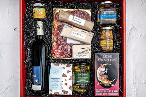 The photo depicts all products within the local gift box with black shred, laid out nicely