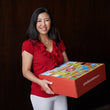 Load image into Gallery viewer, Michelle, owner of Granville Island Delivery Co., holding a holiday gift box featuring local Vancouver products.
