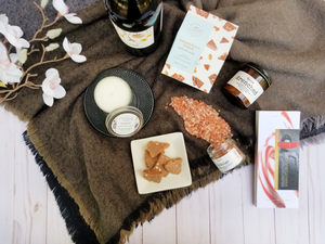 Shot from above are a selection of indulgent items such as bath salts, chocolate, body butter, local red wine and seasonal candle. 